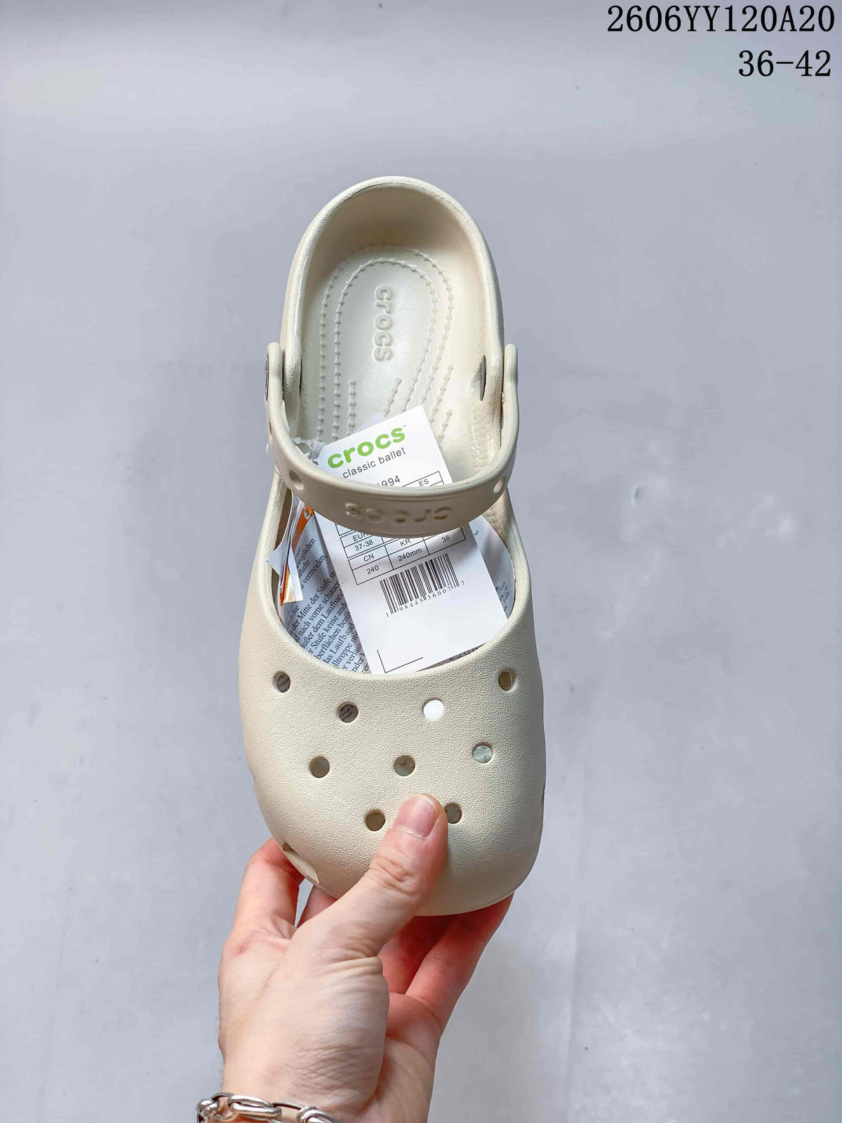 Top view of a single cream clog with perforated toe and heel strap.