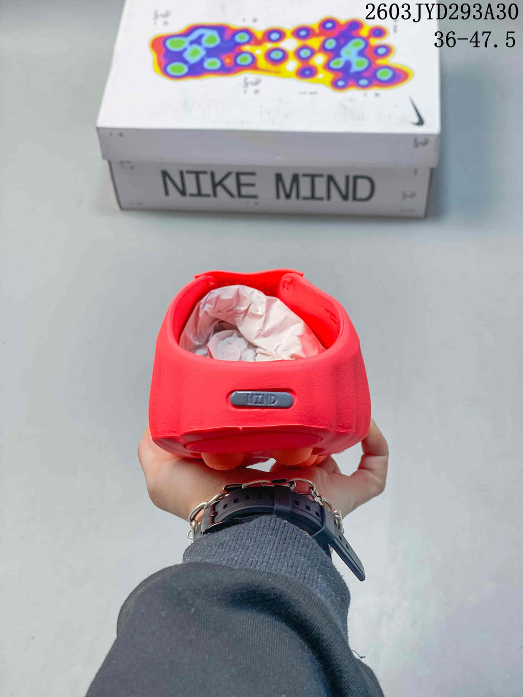 Heel view of a bright red Nike Mind slide with a small Mind badge.