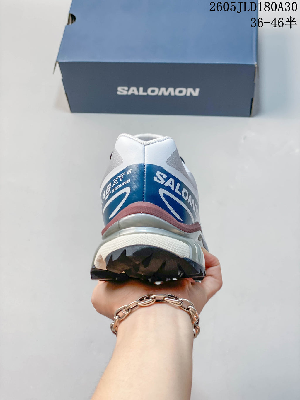 Rear view of a Salomon XT-6 shoe with blue and burgundy accents