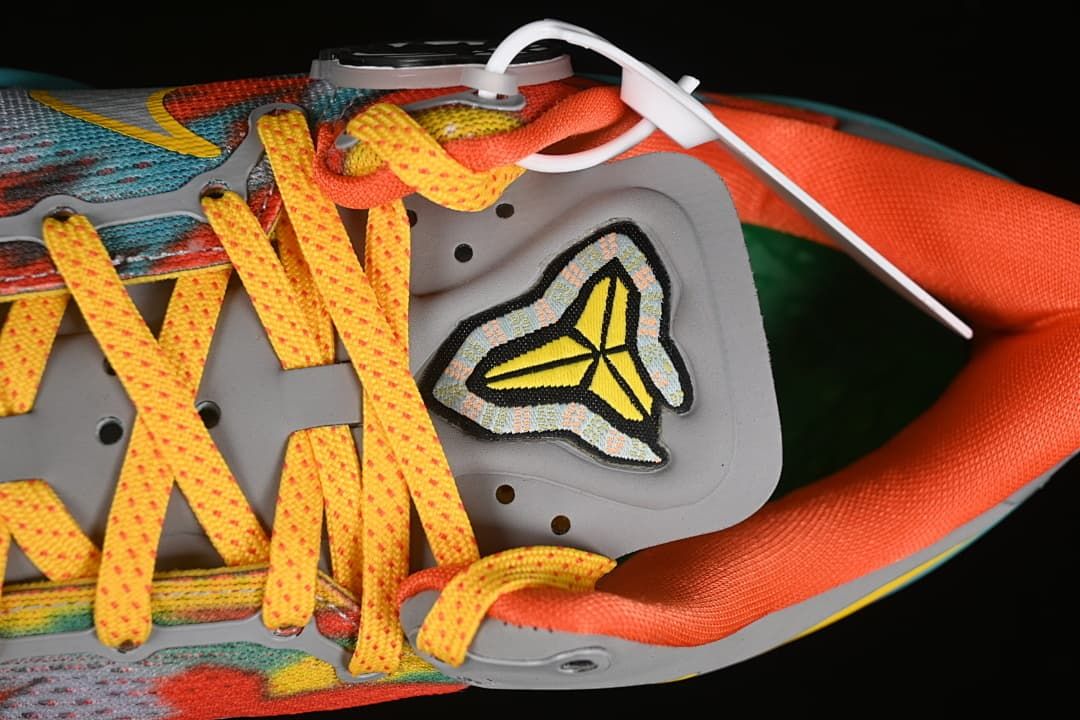 Top-down detail of the yellow laces, tongue emblem, and orange lining