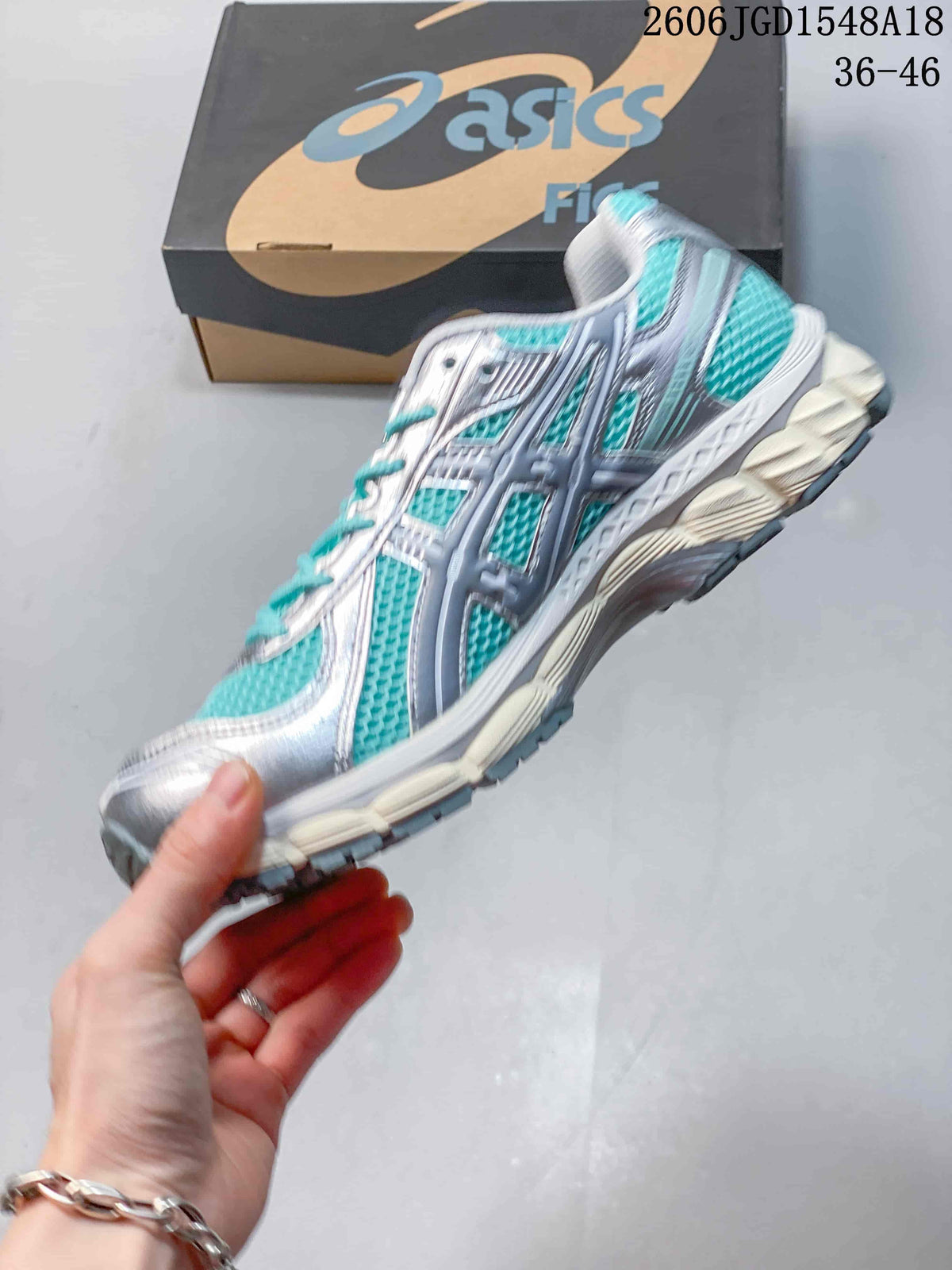 Side view of a silver and turquoise ASICS GEL-KAYANO 12.1 shoe.