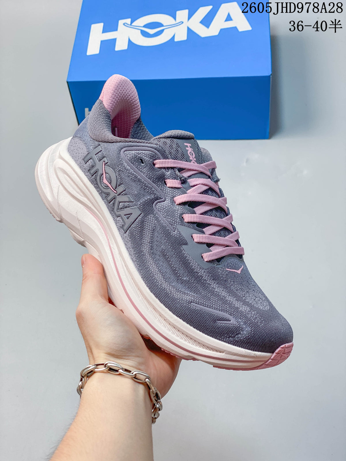 Angled side view of a gray HOKA Clifton 10 running shoe with pink accents