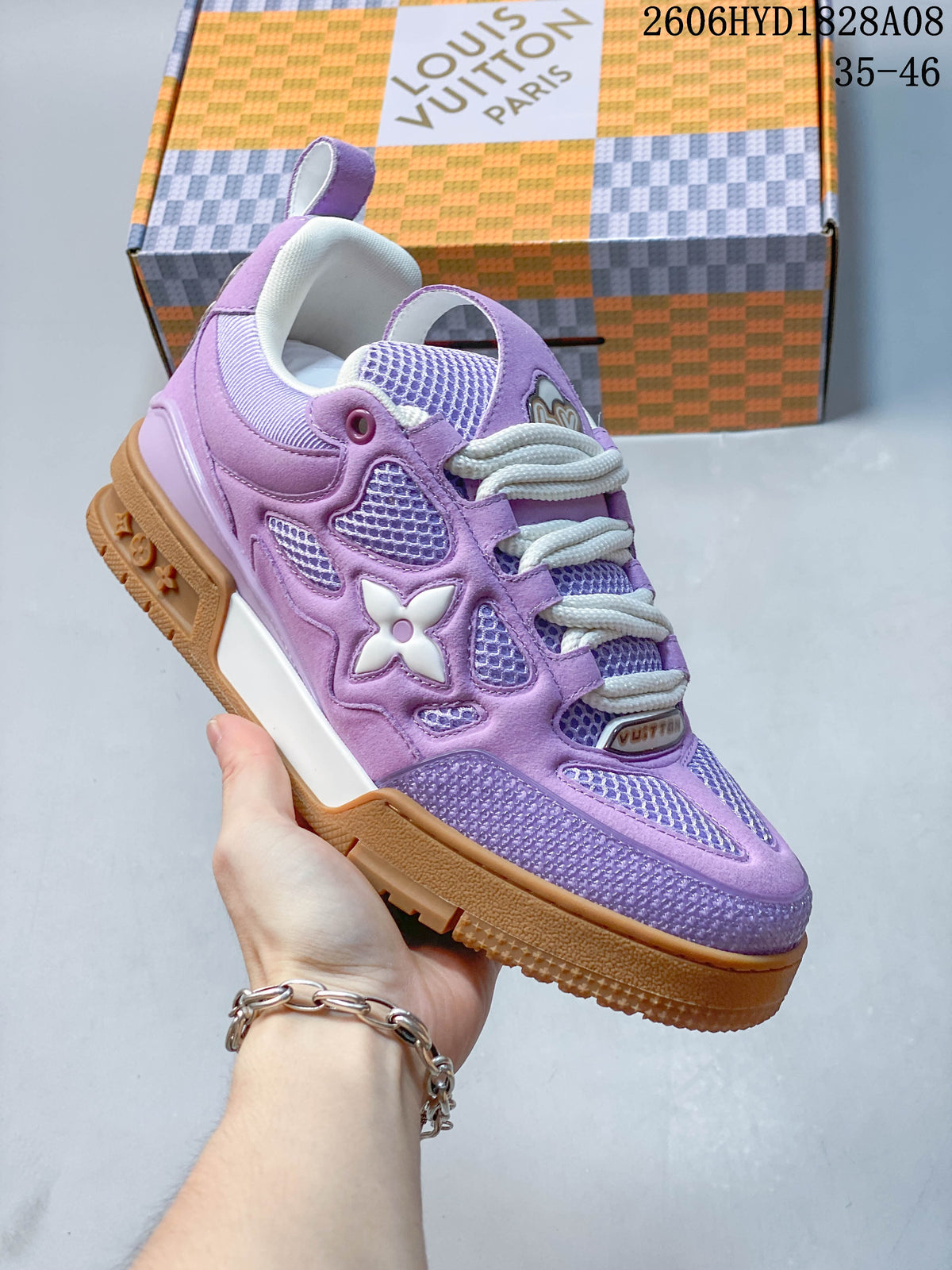 Close-up of a purple low-top sneaker showing its layered panels, mesh details, and side emblem.