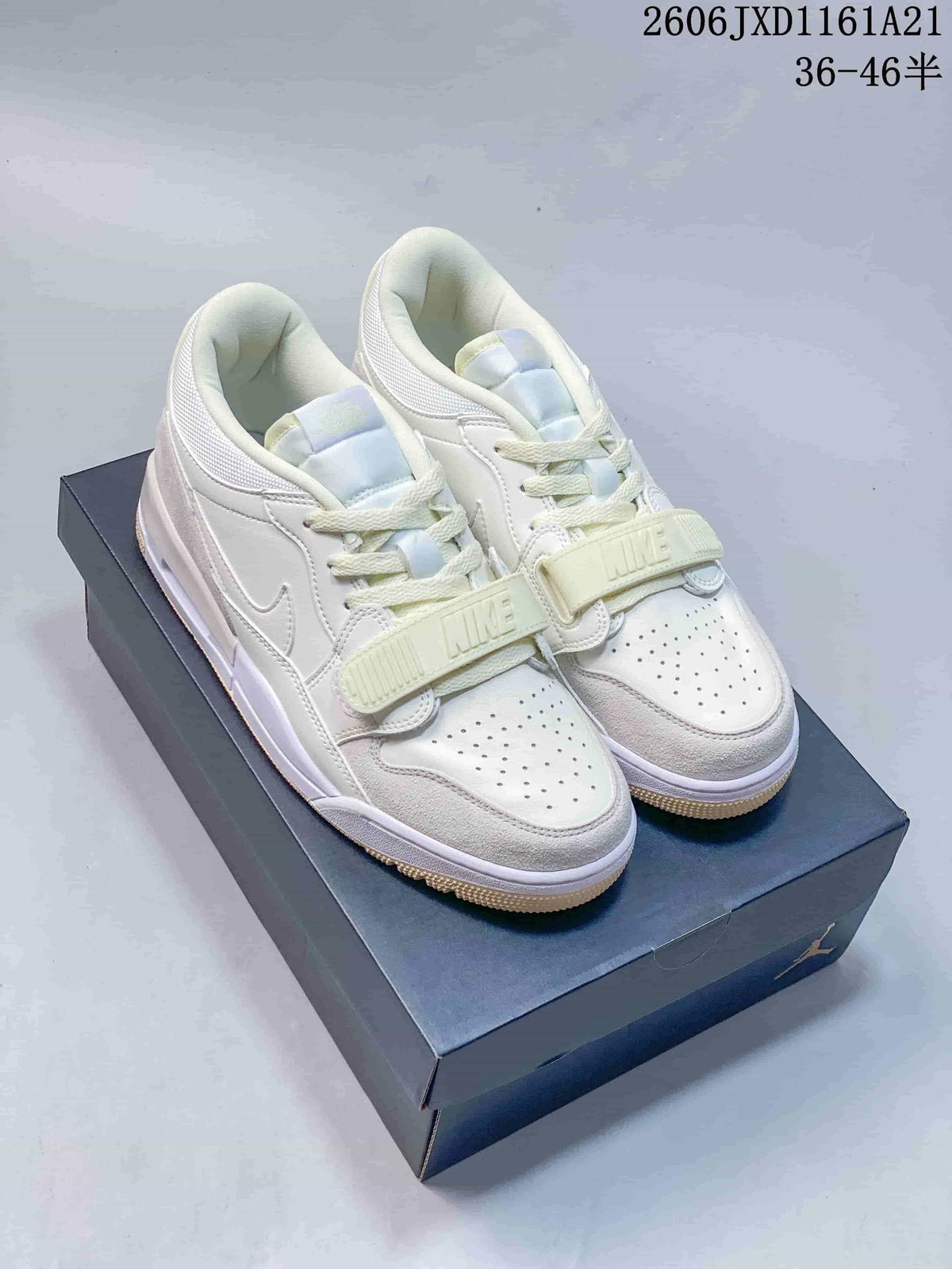 Pair of pale cream and white Jordan Legacy 312 Low sneakers with front straps and gum-colored outsoles