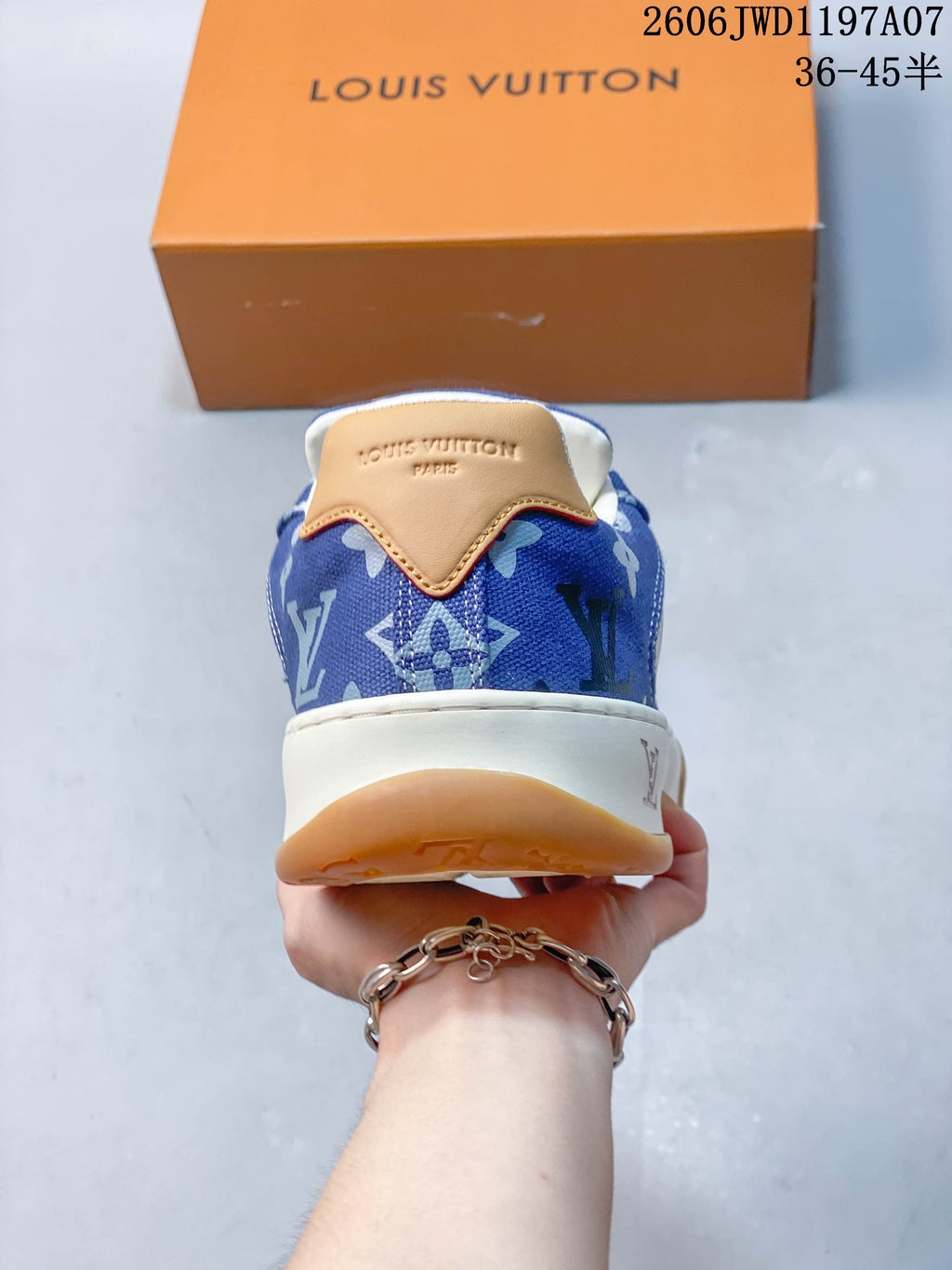 Rear view of the sneaker with a tan heel tab and blue patterned upper
