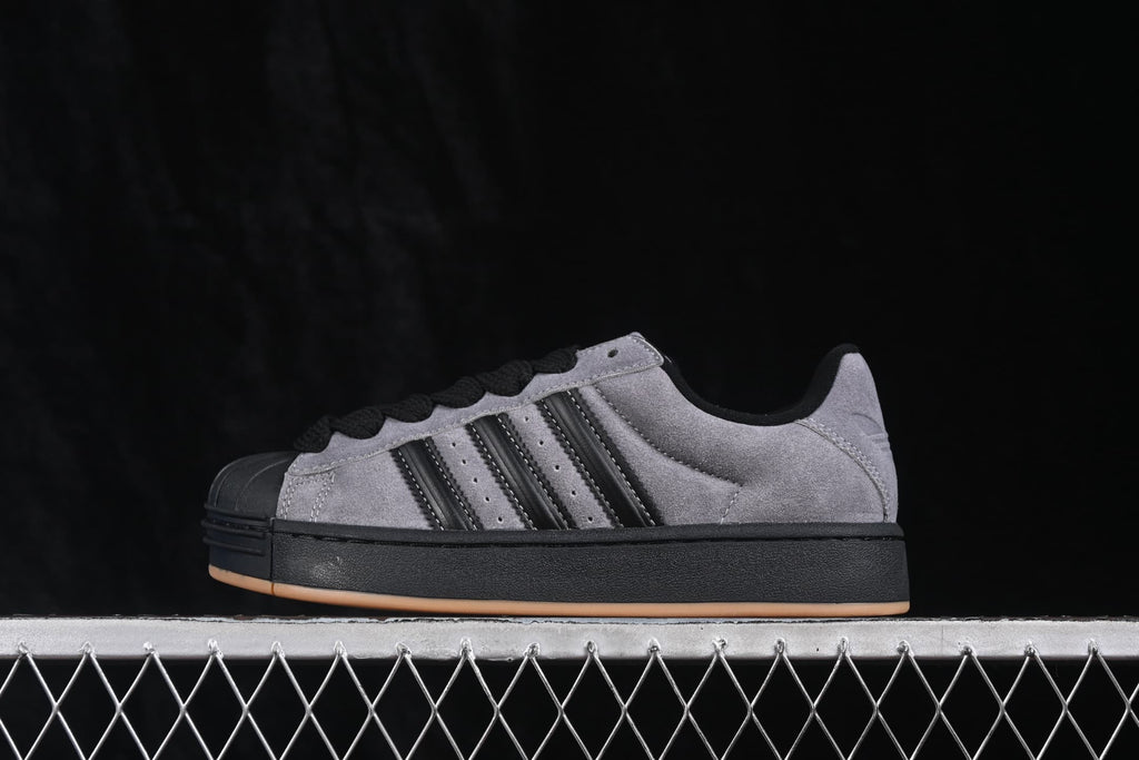 Opposite side profile of the low-top grey and black sneaker with contrasting stripes and gum outsole.