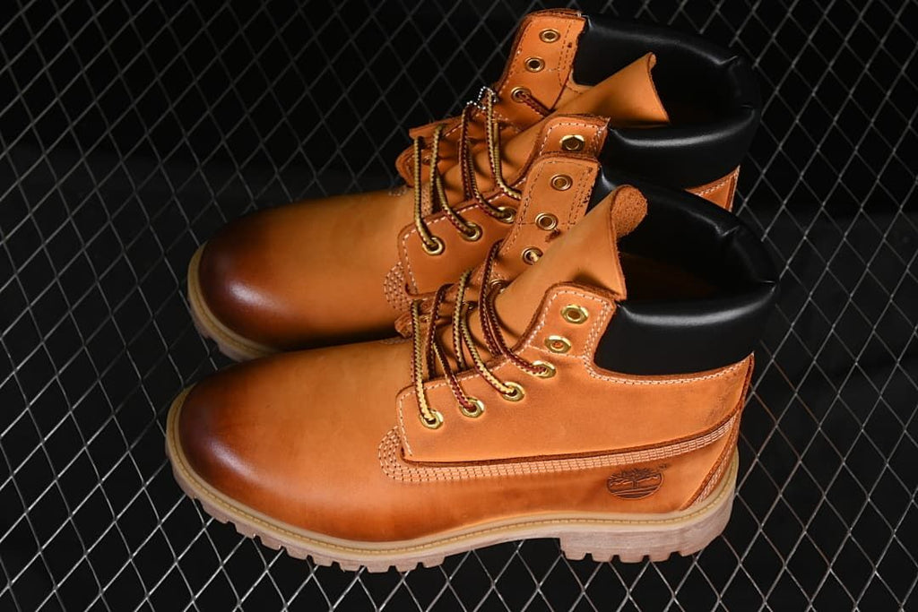 Pair of wheat-colored lace-up boots with black padded collars