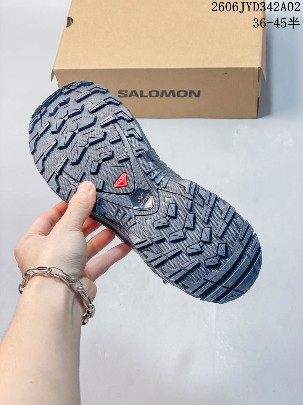 Close-up of the deeply treaded outsole of a dark gray trail running shoe