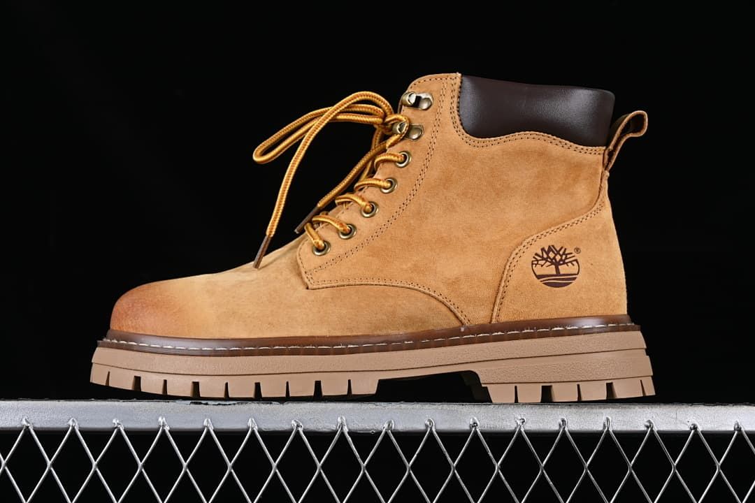 Side view of a wheat-brown Timberland mid-top lace-up boot with a lugged sole