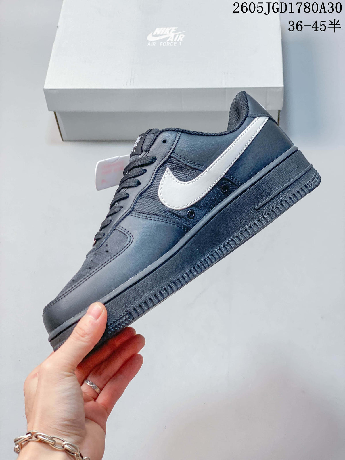 Side view of a dark gray Nike Air Force 1 Low sneaker with a light-colored Swoosh.