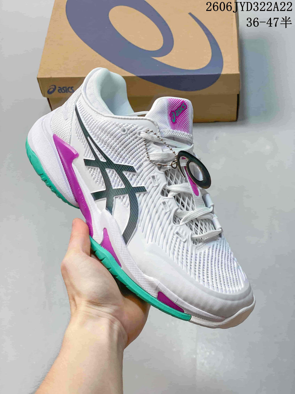 Angled side view of a white ASICS tennis shoe with teal and magenta details.
