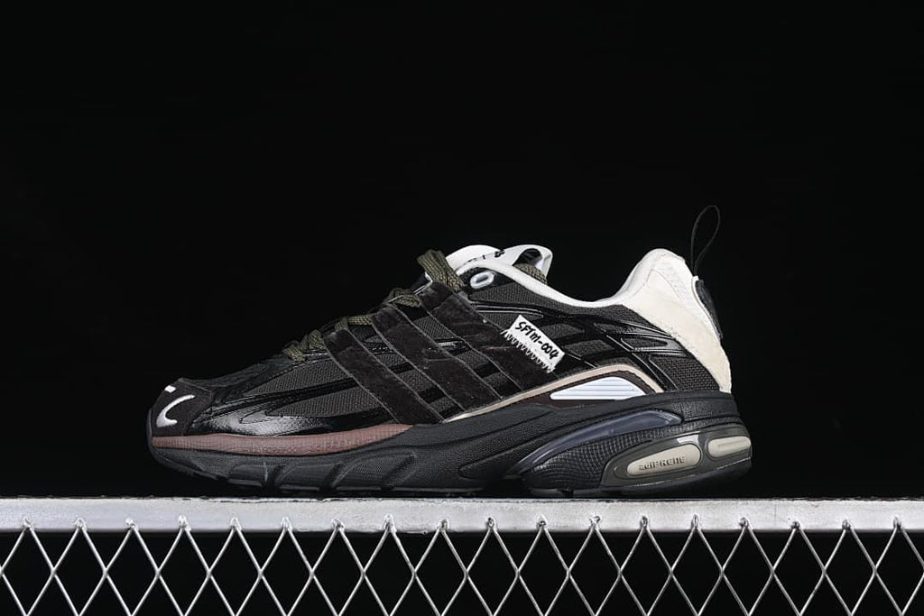 Side view of a black adidas Adistar Cushion SFTM sneaker with olive-toned laces and off-white heel accents.