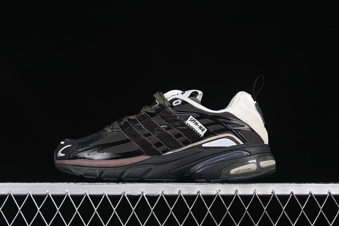 Side view of a black adidas Adistar Cushion SFTM sneaker with olive-toned laces and off-white heel accents.