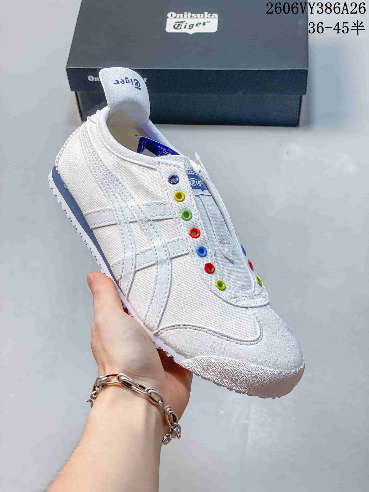 Angled side view of the white sneaker showing its stripes, colorful eyelets and blue heel accent