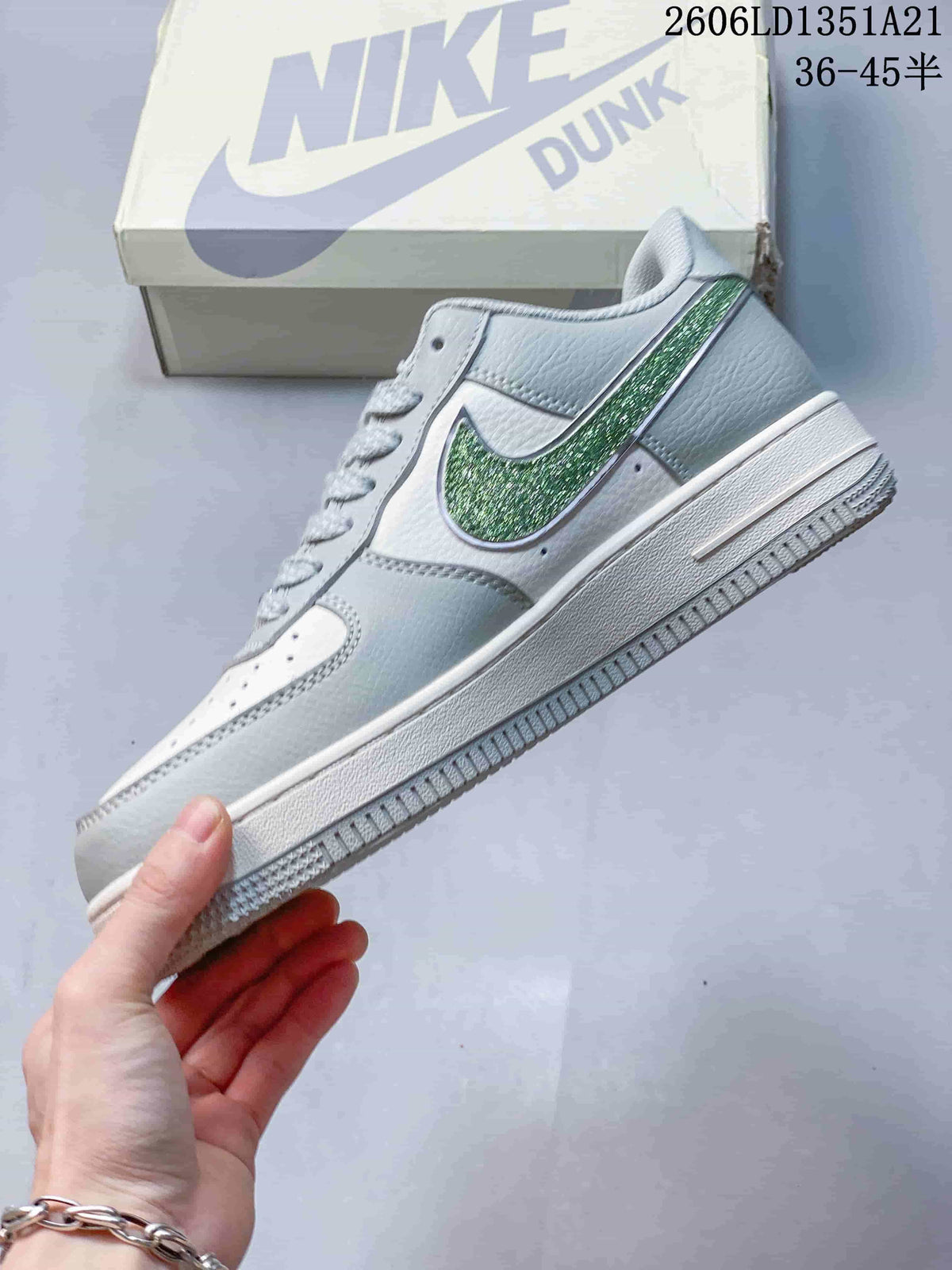 Side view of the sneaker with a green glitter-look Swoosh and white midsole