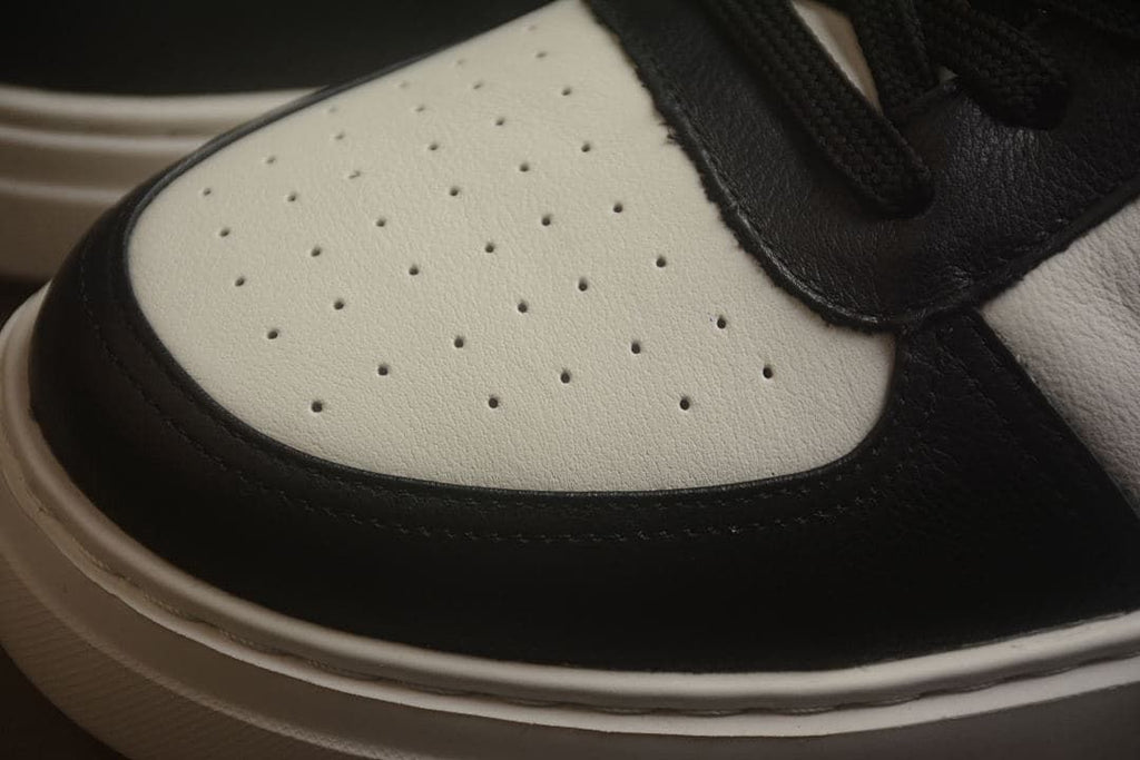 Close-up of the perforated light-colored toe panel and dark trim