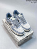 Pair of pale grey and off-white low-top sneakers with patterned laces and speckled accents, shown on a branded box.