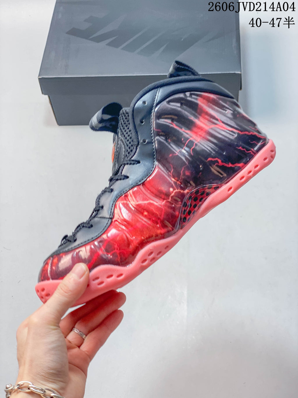 Side view of the high-top shoe with navy laces, red graphics and coral outsole.