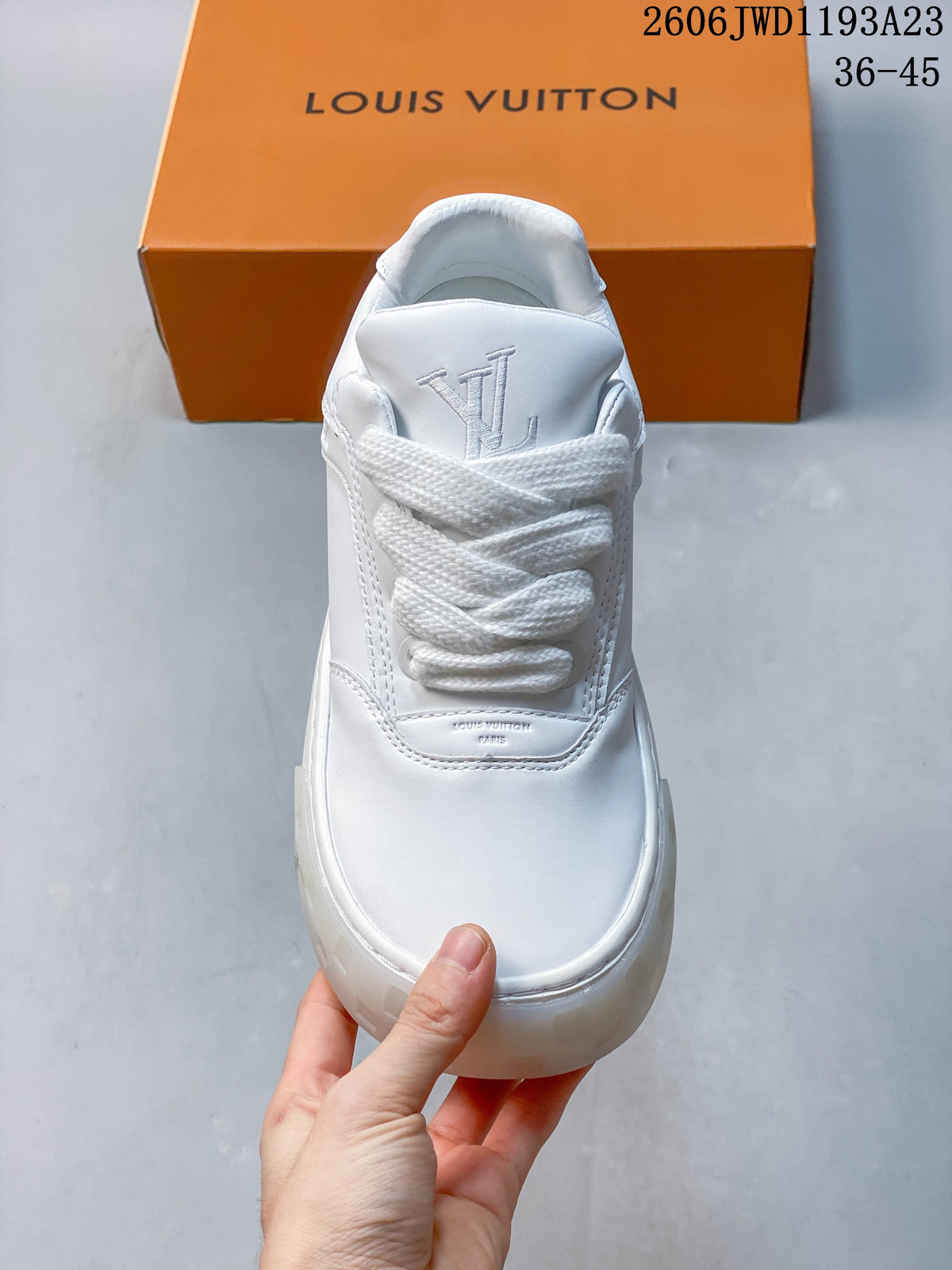 Front view of a white sneaker showing laces and tongue logo
