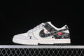 Side view of a white and black low-top SB Dunk-style sneaker with patterned overlays and red accents