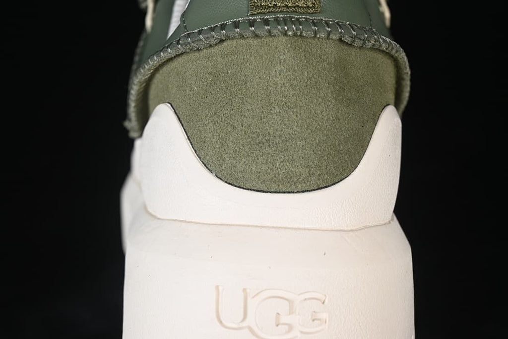 Rear close-up of the green sneaker and raised UGG heel branding