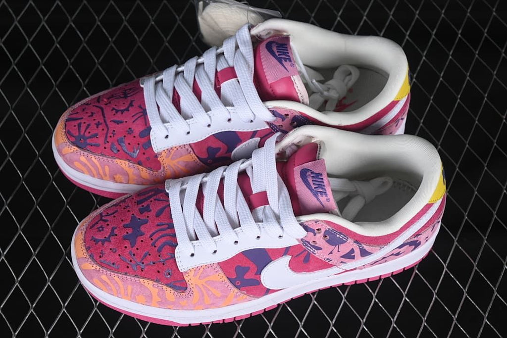 Top view of a pair of multicolor printed low-top sneakers with white laces and pink tongues