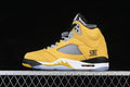 Side view of a yellow, black, white, and grey Jordan Air Jordan 5 Retro sneaker