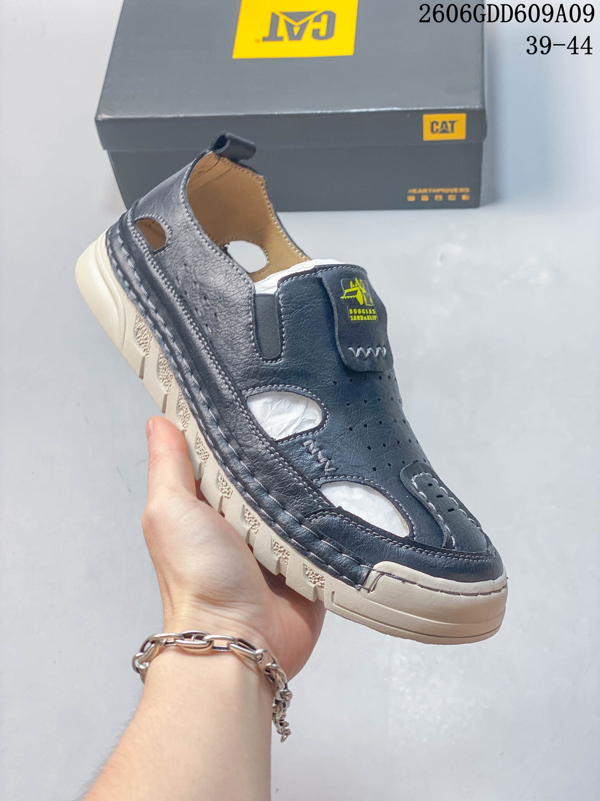 Angled view of a navy fisherman sandal with open cutouts and a light-colored treaded sole; image overlay shows sizes 39–44.