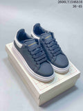 Pair of navy low-top lace-up sneakers with white chunky soles and heel panels