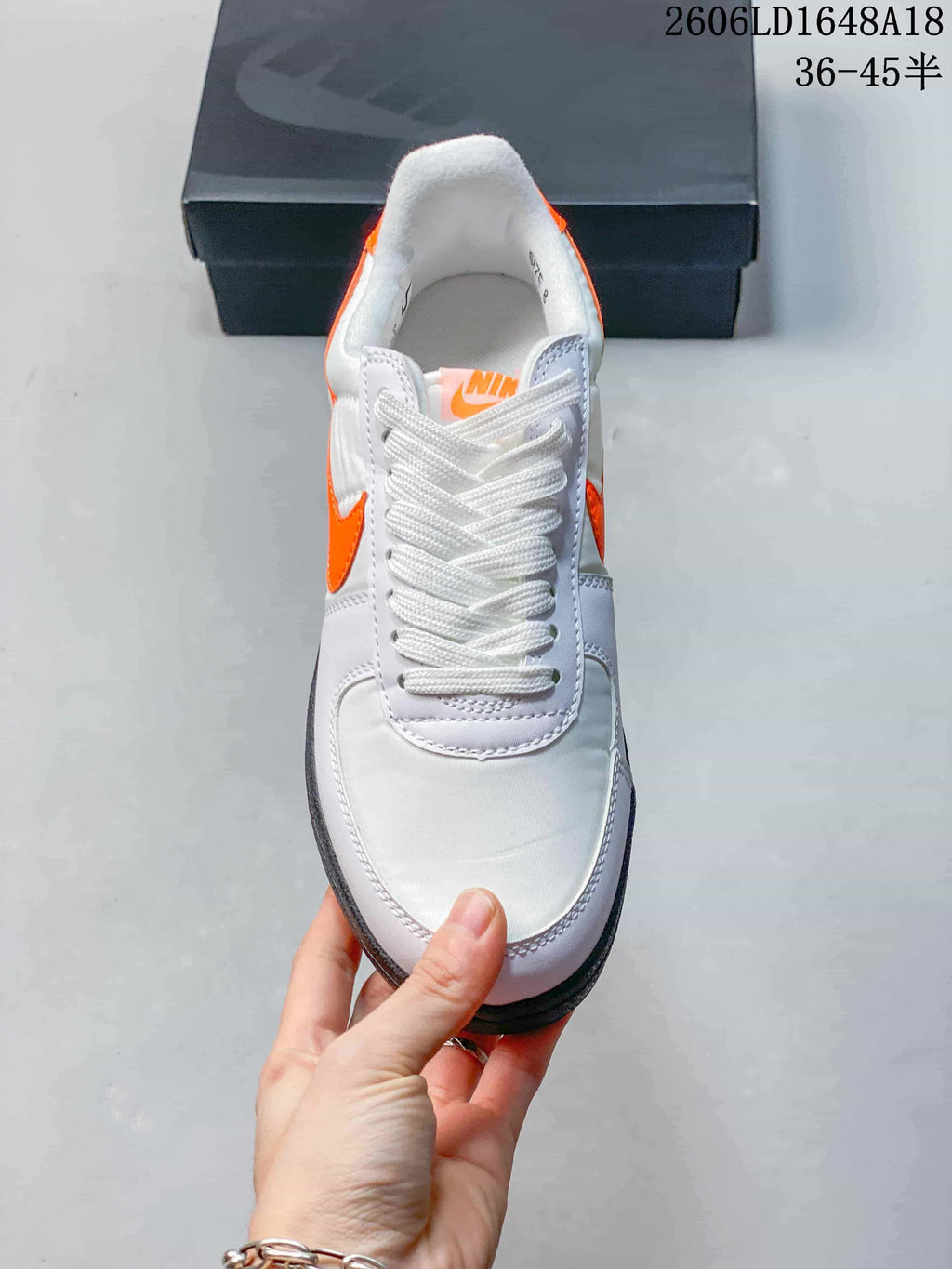 Front view showing white laces, orange tongue detail, and stitched overlays
