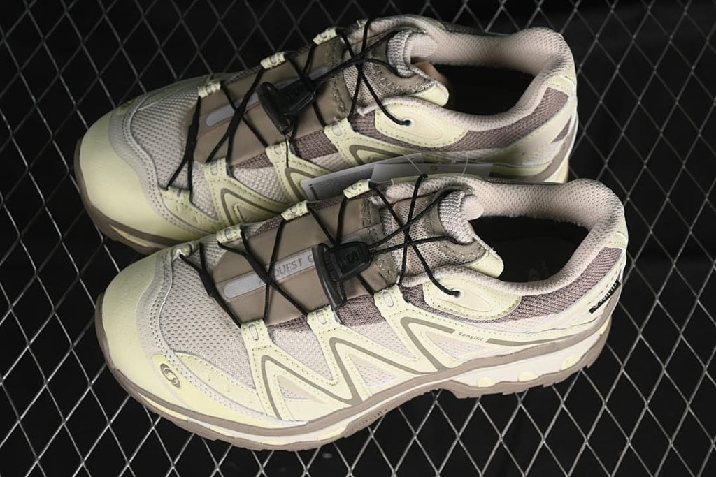 Pair of pale yellow and taupe Salomon XT-Quest shoes