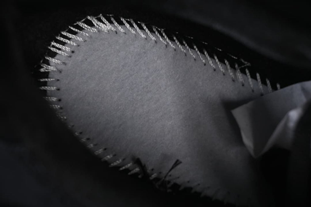 Close-up of stitching along a shoe panel.