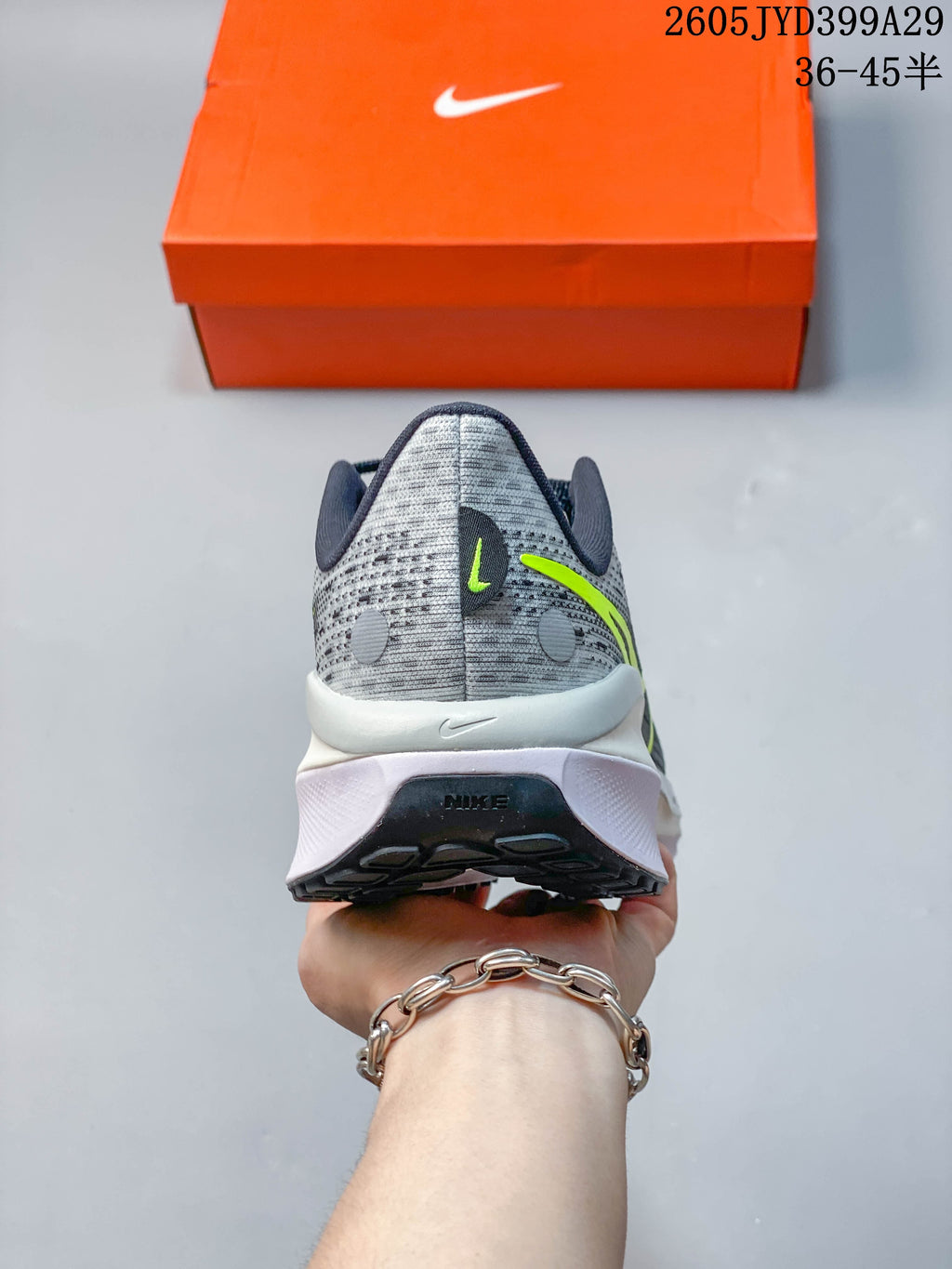 Rear view of the gray running shoe with lime accents and layered midsole.