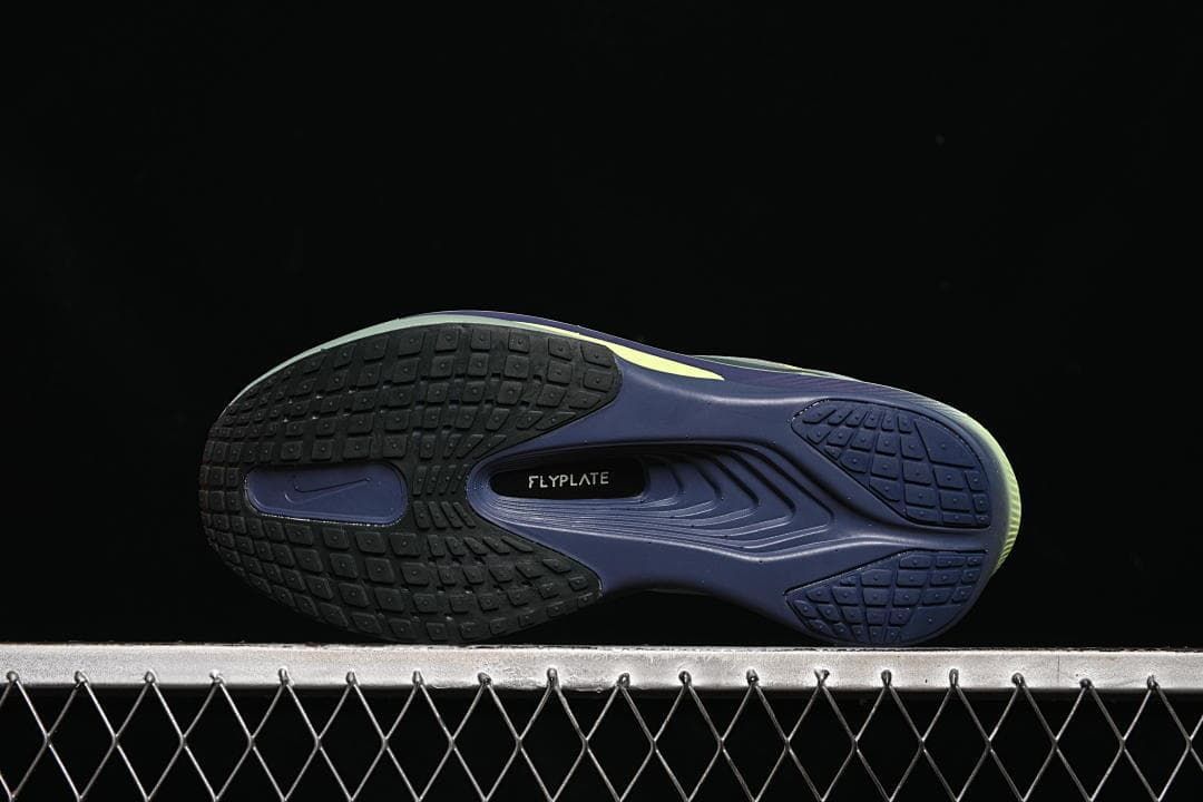 Underside view showing segmented outsole tread and Flyplate marking