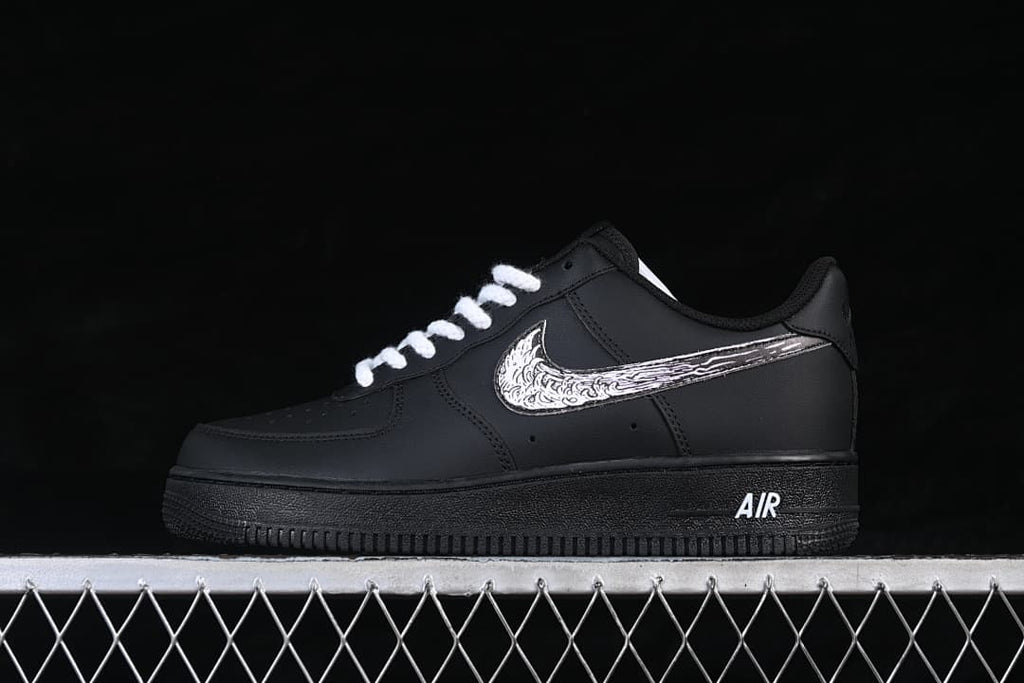 Side view of a black low-top sneaker with white laces and an illustrated Swoosh graphic