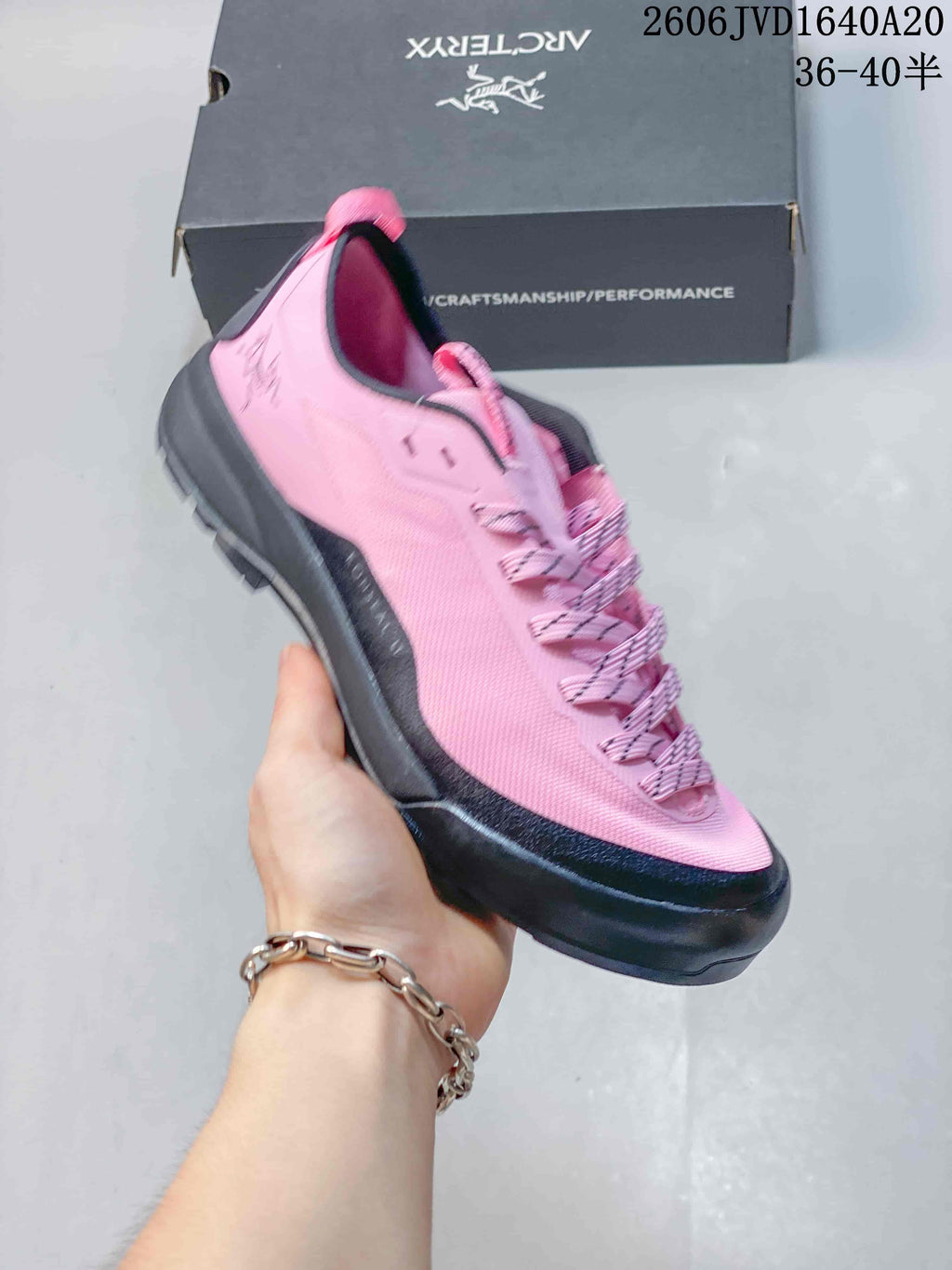 Angled side view of a pink trail shoe with dark gray outsole
