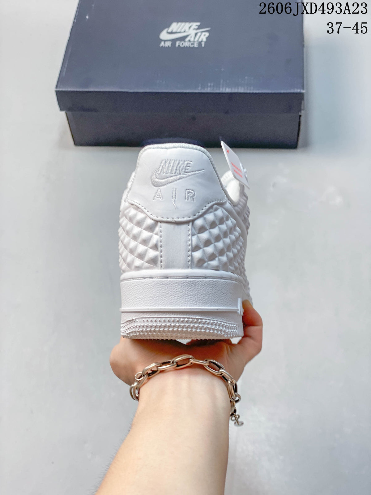 Rear view of the white sneaker with raised geometric heel panels