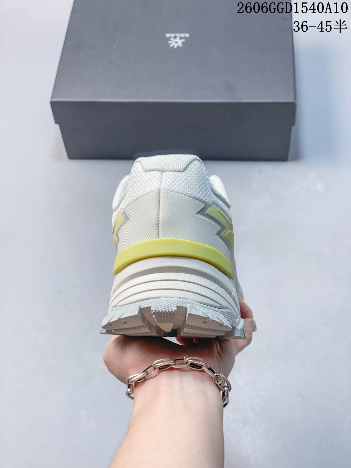 Rear view of the white and pale lime hiking shoe, showing the heel and outsole lugs.