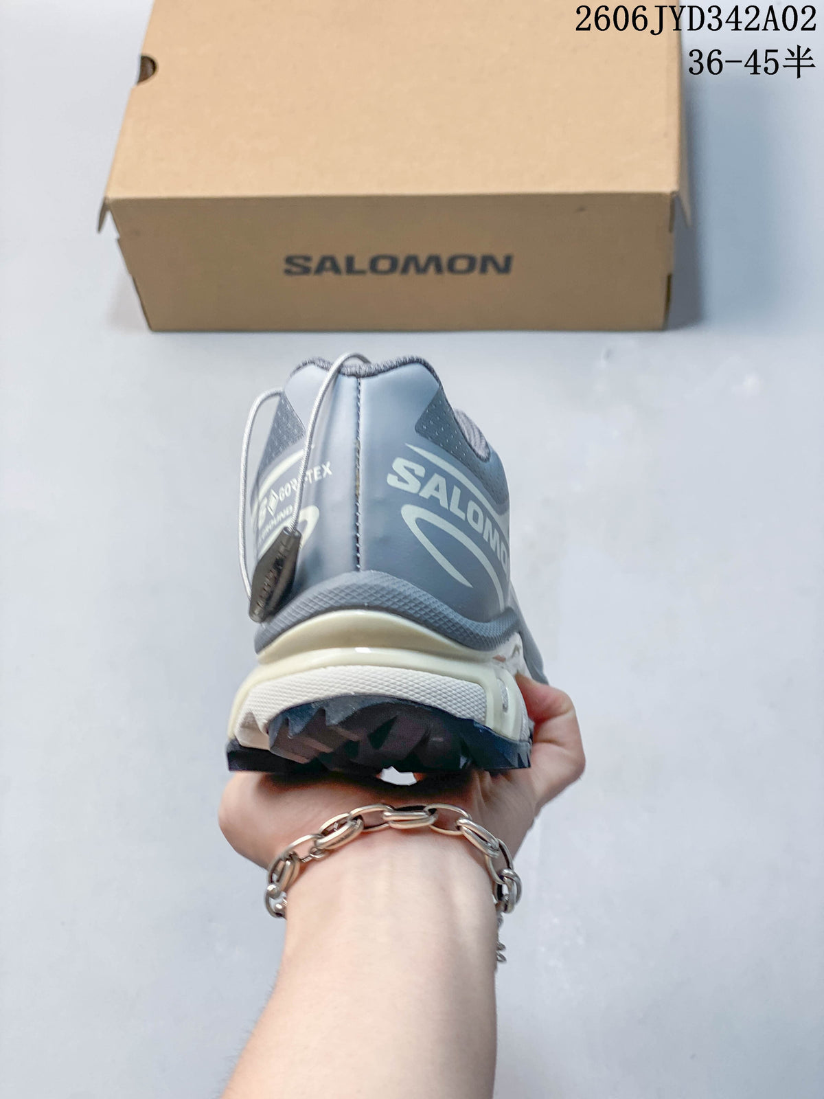 Rear view of a gray Salomon trail running shoe with branded heel details
