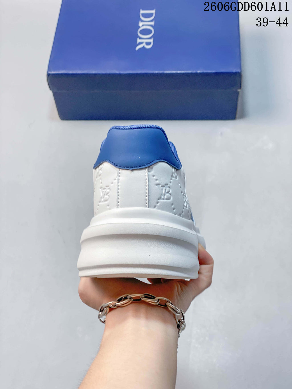 Rear view of the white sneaker with blue heel and collar accents; image marking shows sizes 39–44.