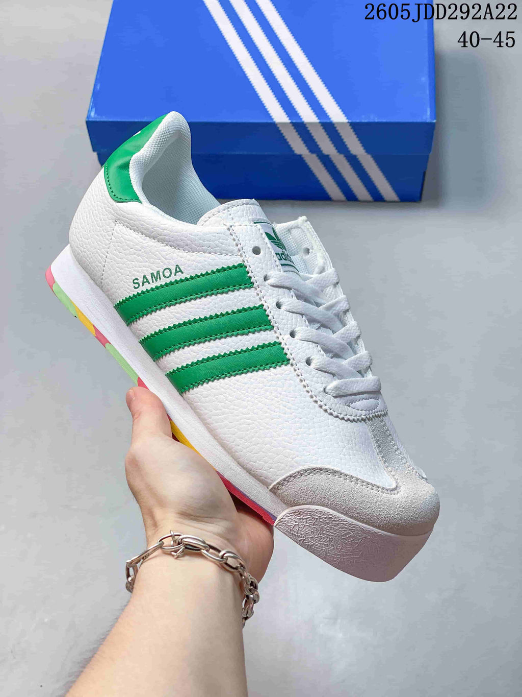 White Adidas Samoa low-top sneaker with green stripes and colorful sole accents
