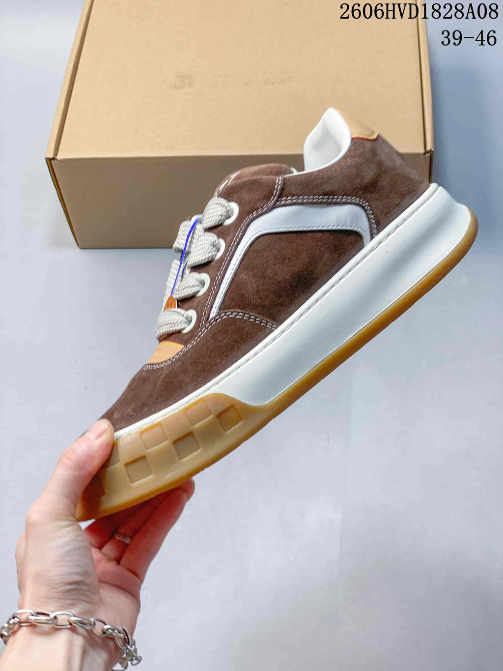 Side view of a brown low-top sneaker with white paneling and a gum-colored outsole