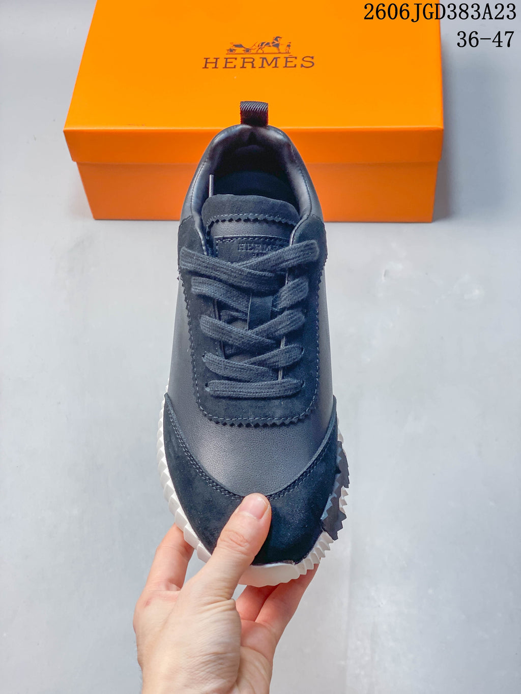Front view of a navy lace-up sneaker with a rounded toe and contrasting panels