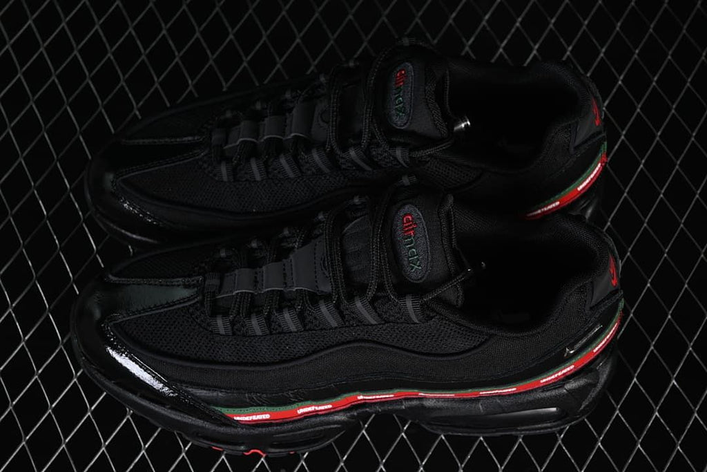 Pair of black Nike Air Max 95 SP sneakers with red-and-green side details