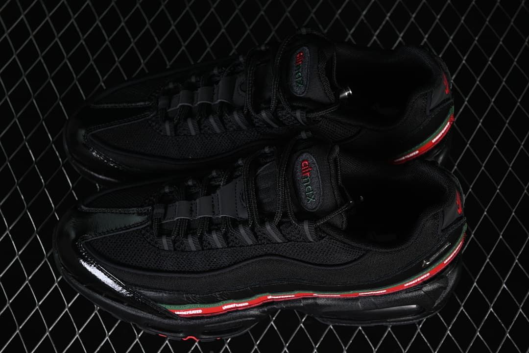 Pair of black Nike Air Max 95 SP sneakers with red-and-green side details