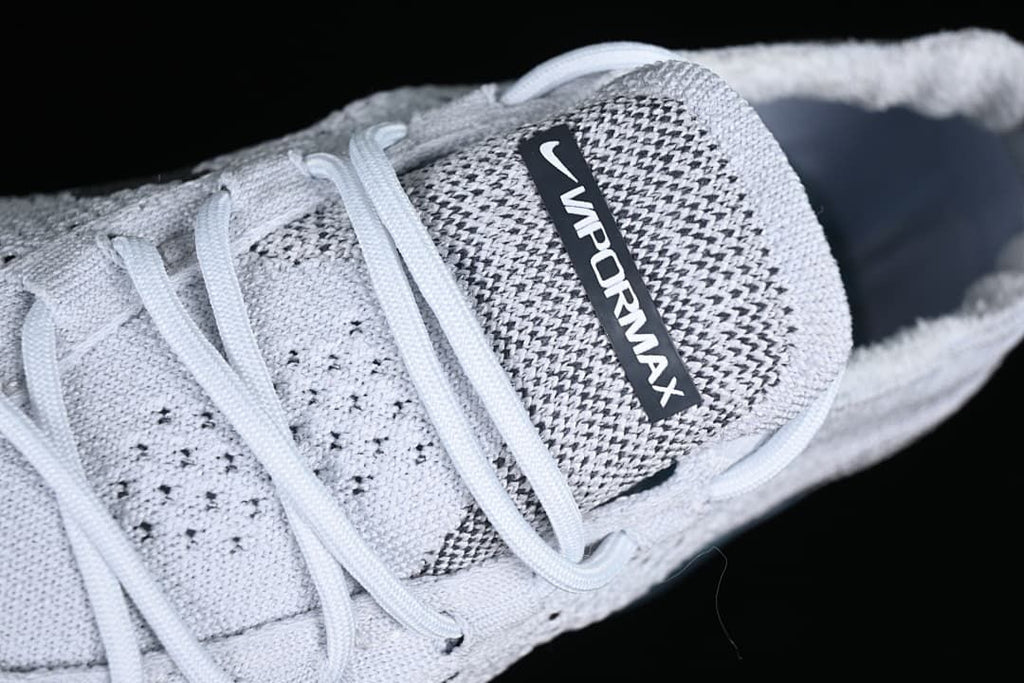 Close-up of the VaporMax tongue label, laces, and knit-patterned upper.