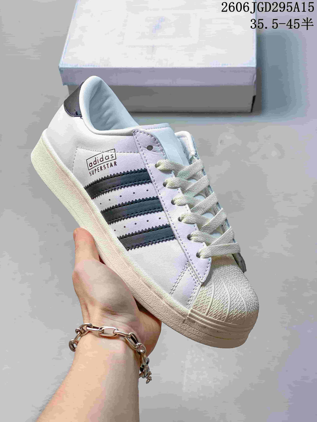 White sneaker with dark three-stripe detailing and a shell toe