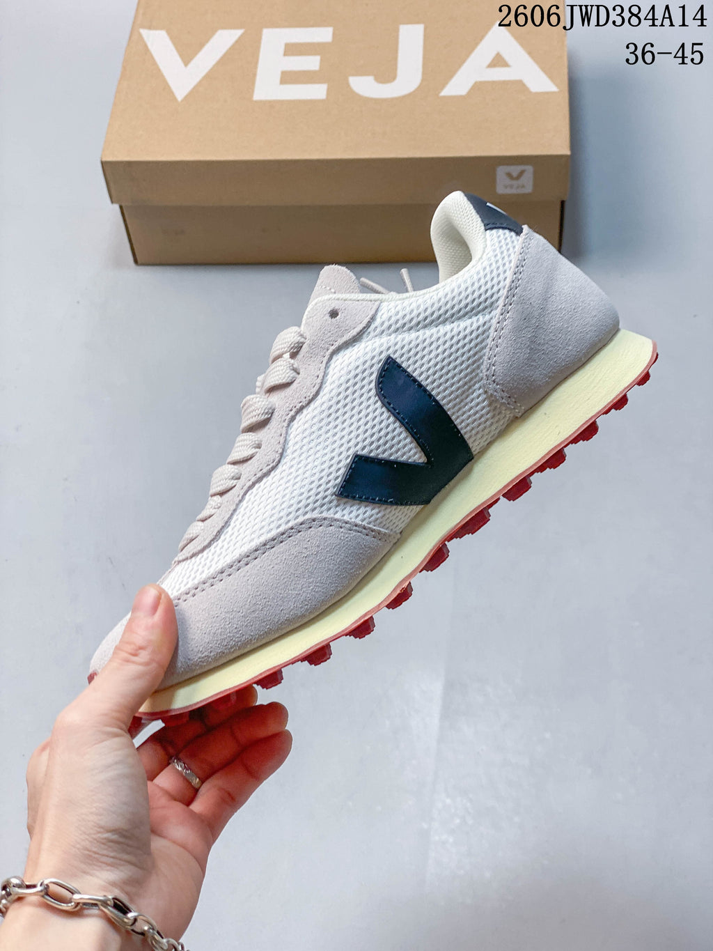 Side profile of a white mesh Veja sneaker with gray overlays and a navy V logo