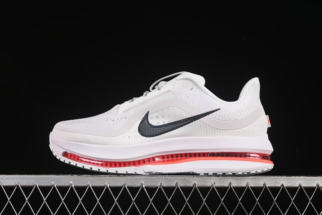 Side view of a white Nike Air Zoom Pegasus Premium shoe with dark Swoosh and red midsole cushioning.