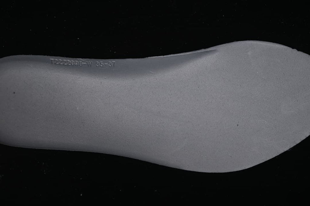 Close-up of the removable-looking gray insole underside with a printed marking